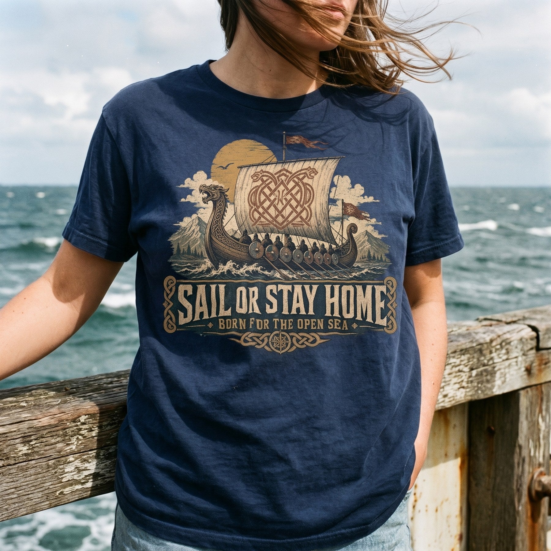 Customer by the sea wearing the Sail or Stay Home longship tee