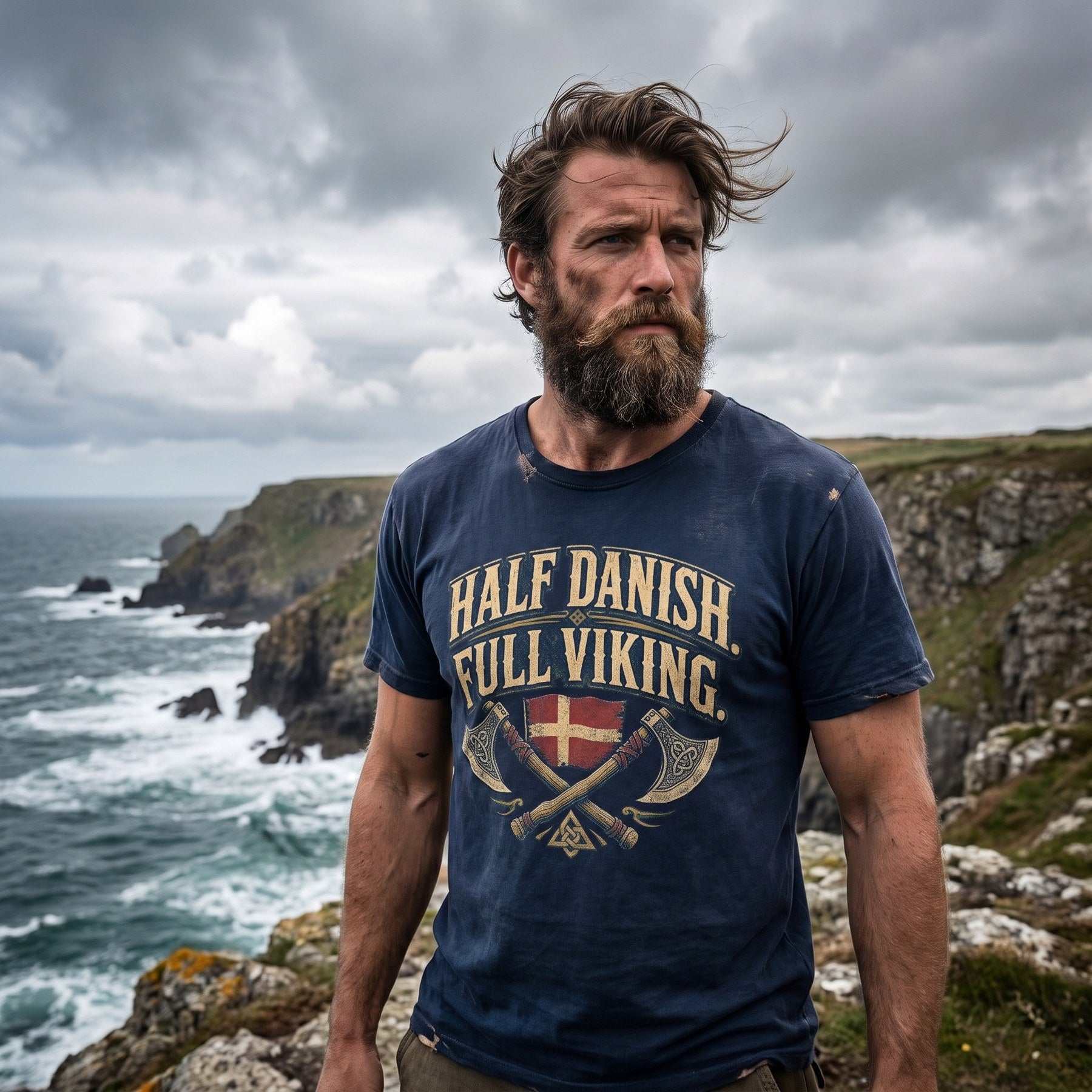 Bearded man on a clifftop wearing the Half Danish Full Viking tee